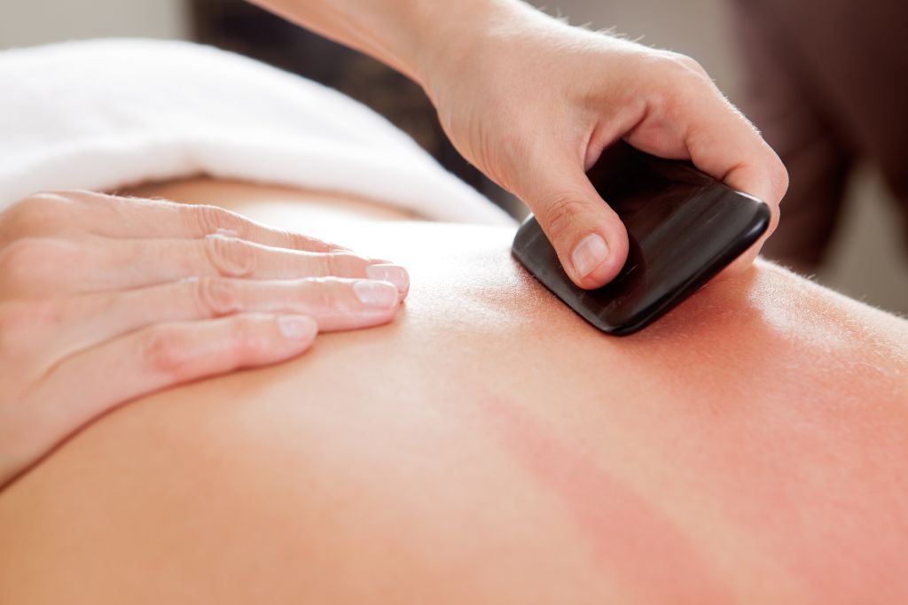 A person having a gua sha massage on her back