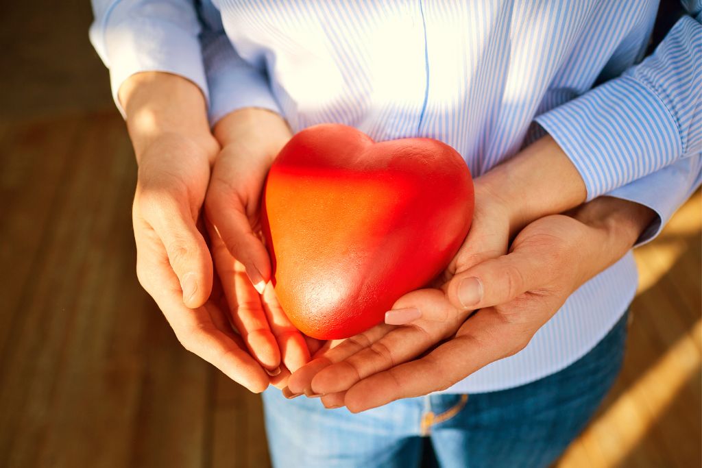 couple's hand holding a heart