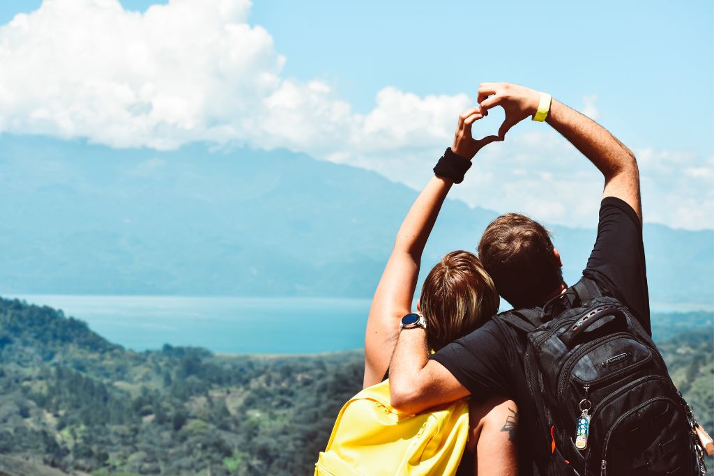 couple sitting together forming a heart-shaped hand