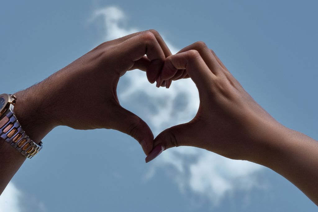 couple creating a heart shape using their hands