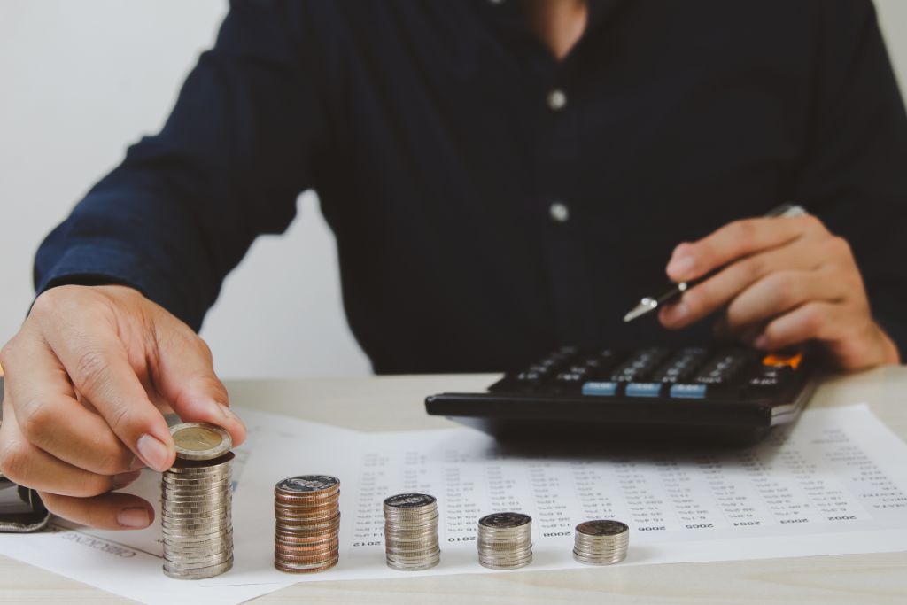 A person is stacking coins on the table