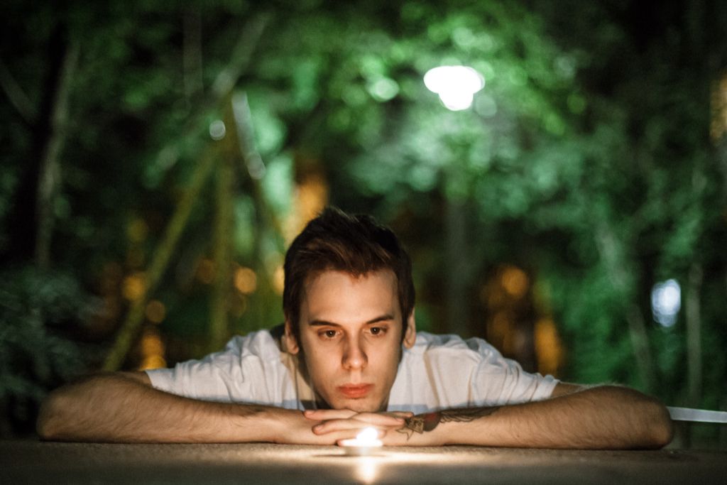 man looking at a candle outdoors x no credit needed