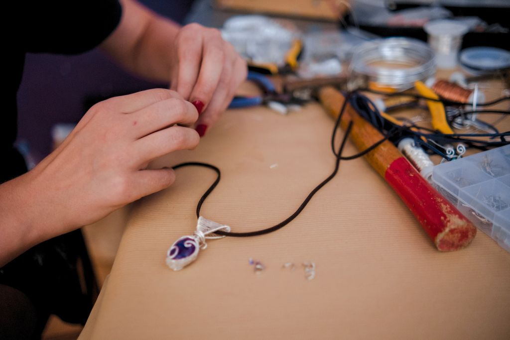 woman doing a DIY crystal wire on a brown table