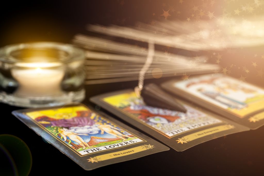 tarot cards together with candle on black platform