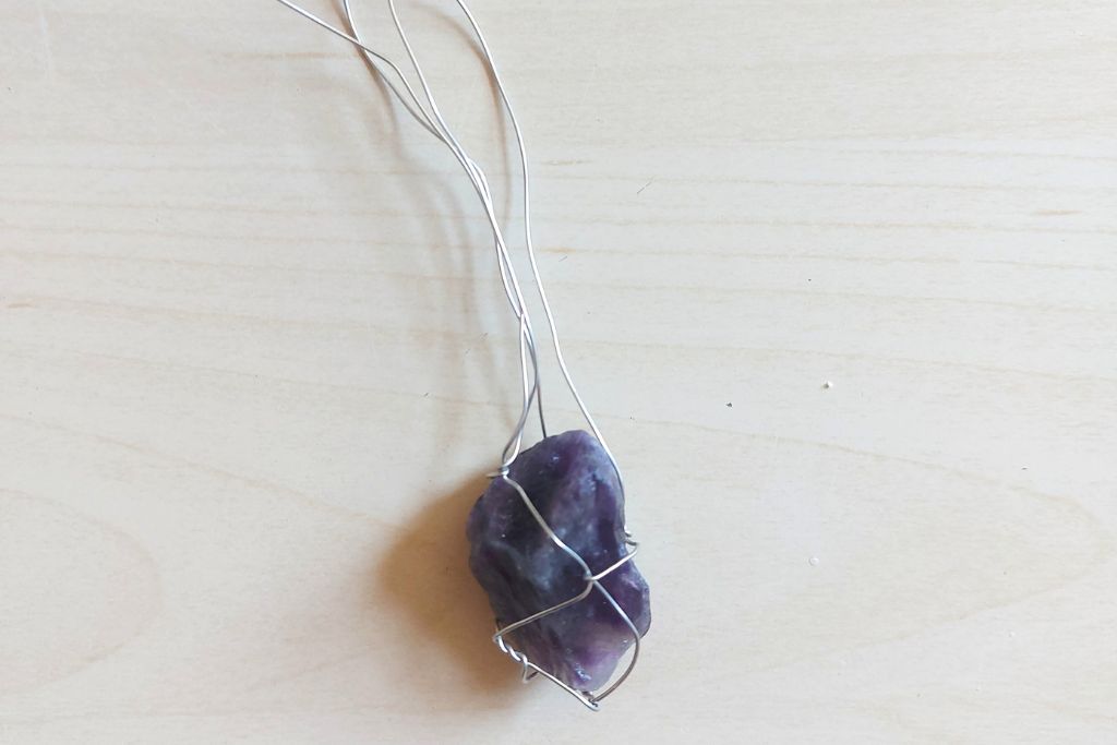 copper wire surrounded to small amethyst crystal