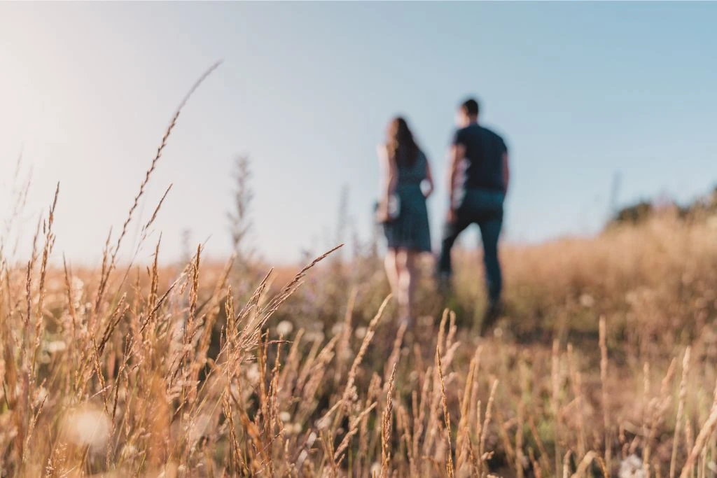 A couple walking on a field of grass