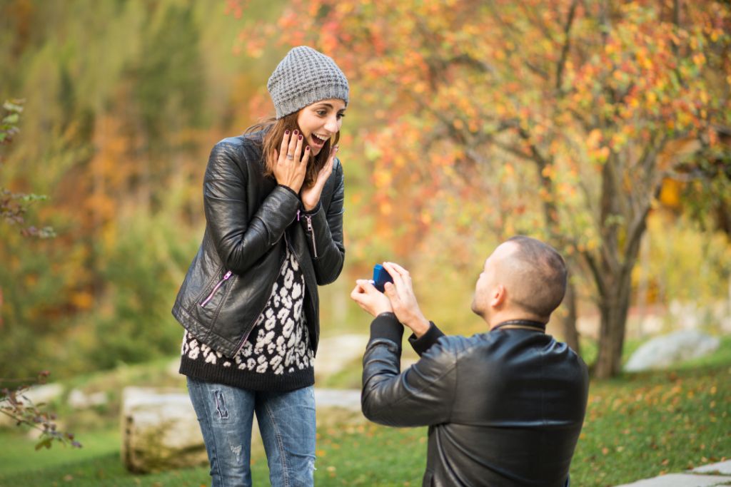 A man is proposing to a woman in nature