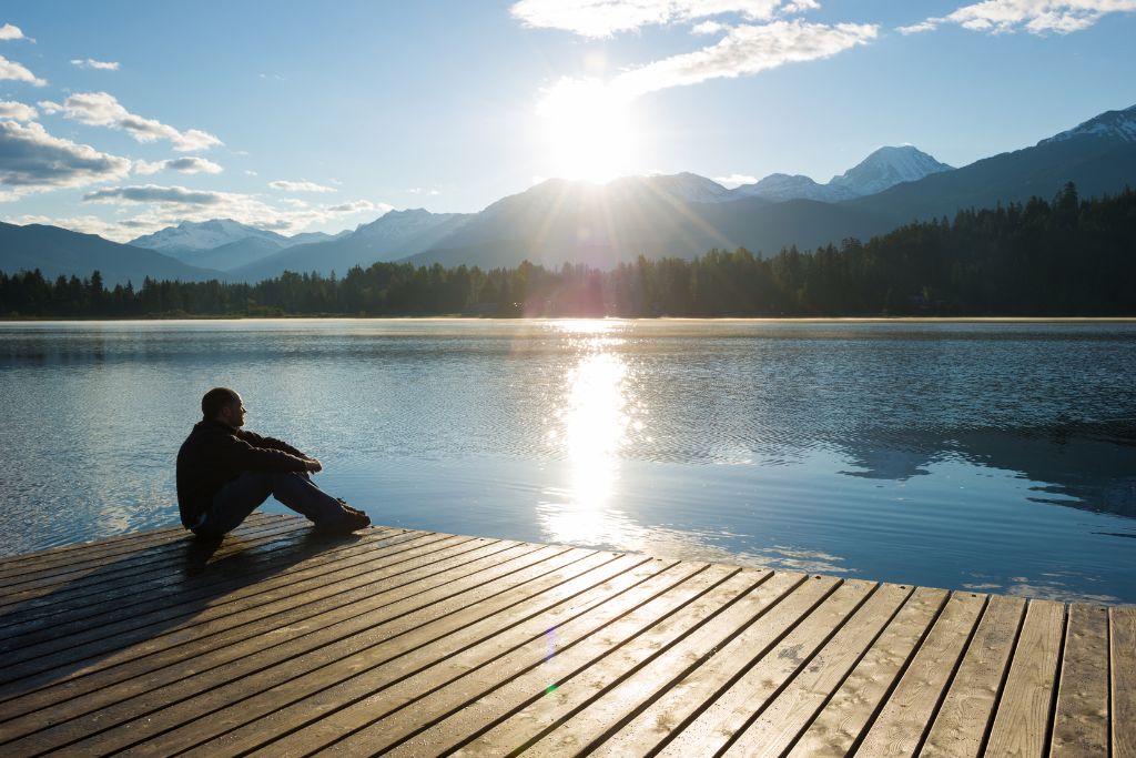A man sitting on a dock in nature