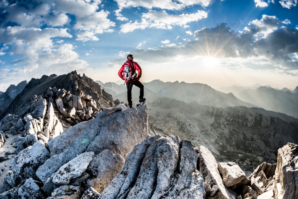 A man is standing on top of the mountain