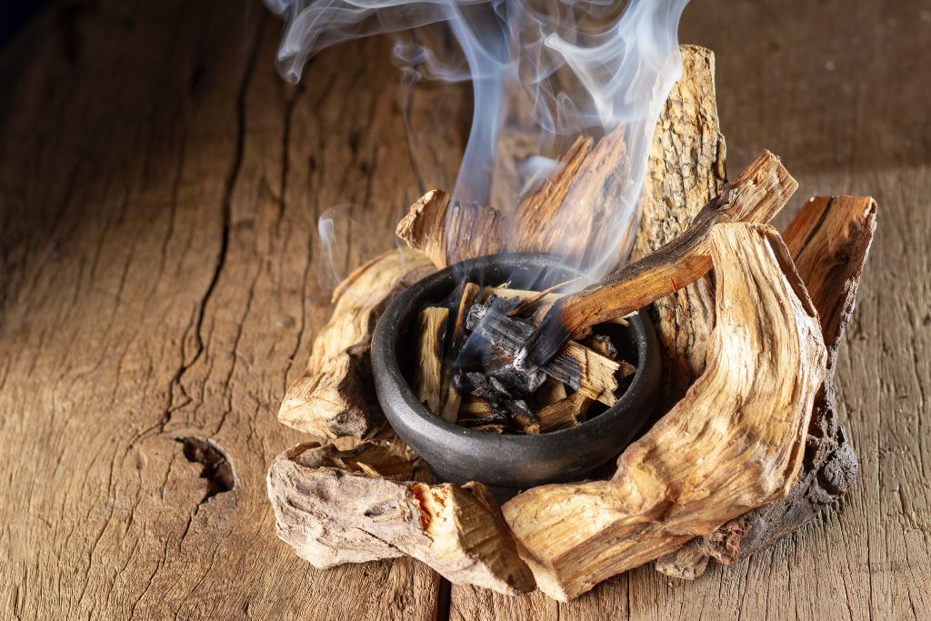 A burning palo santo wood on a bowl