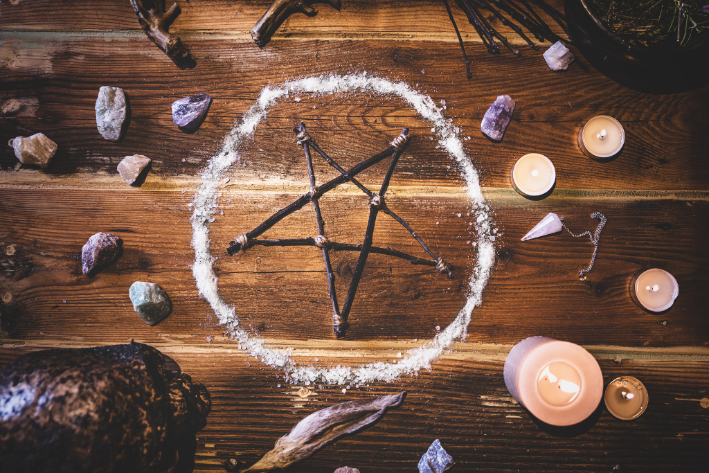 A pentagram and other ingredients or tools use for rituals on the table