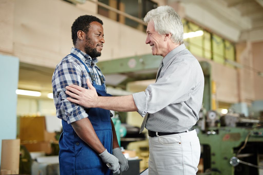 A boss and a worker talking with both smiling