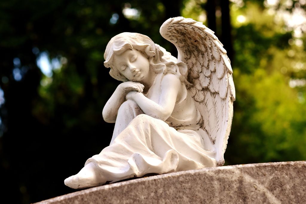 An angel statue on a concrete beam in nature