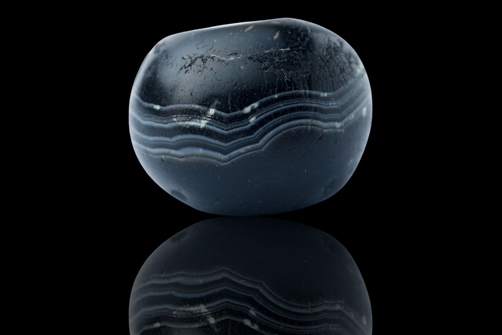 A black agate on a black reflective background