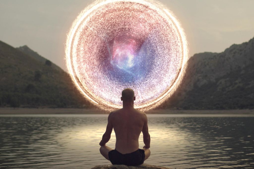 Meditating man opening portal to cosmic energy.