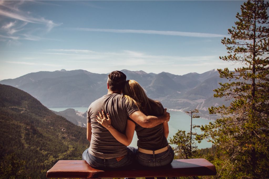 Couple sitting on a bench and looking at the horizon