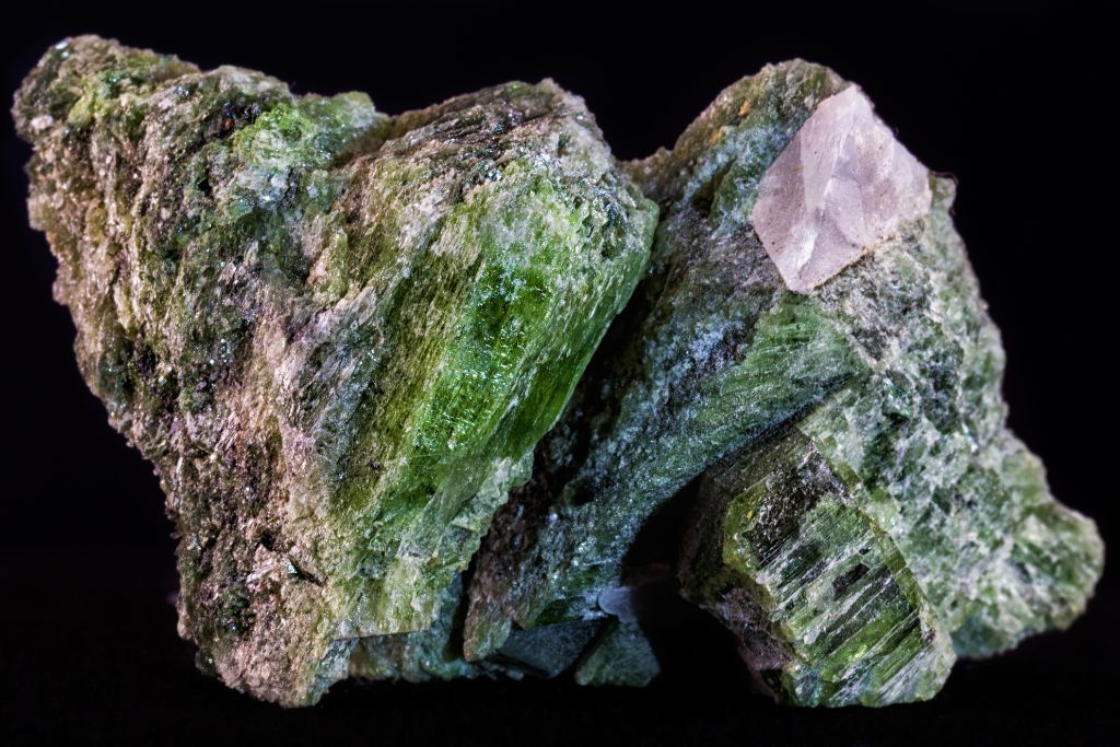 A raw diopside on a black background