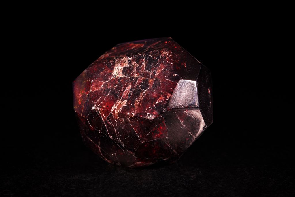 A polished garnet crystal on a dark background