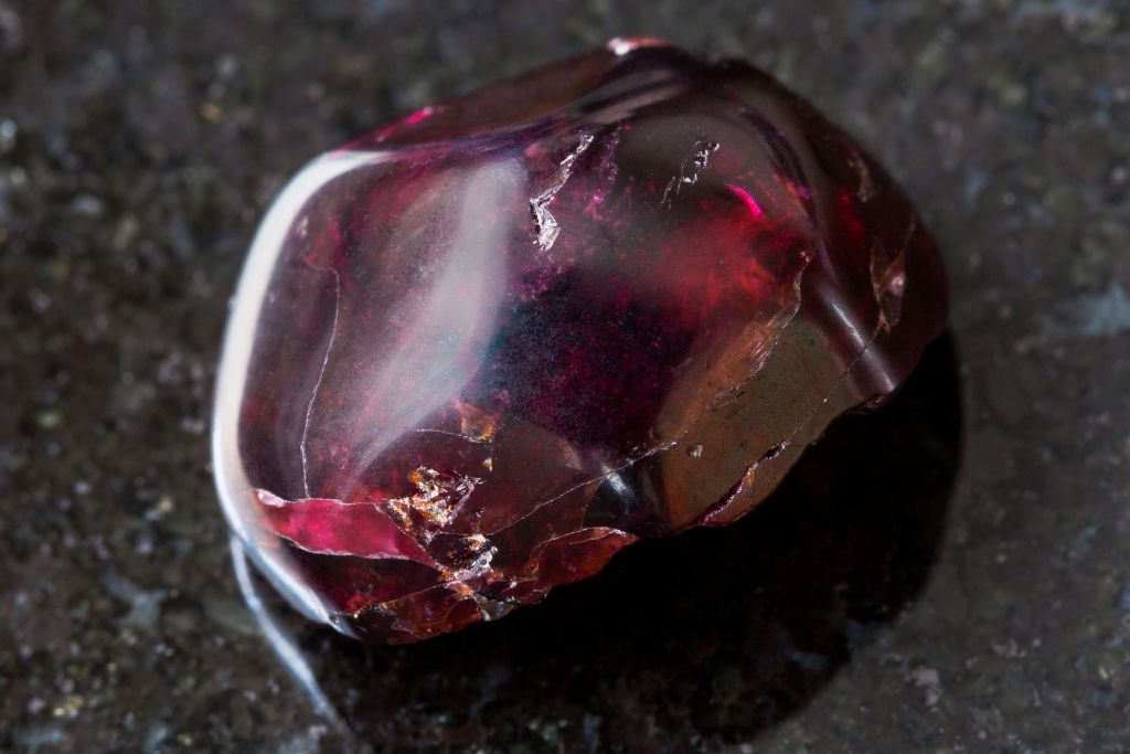 A garnet crystal on a black granite