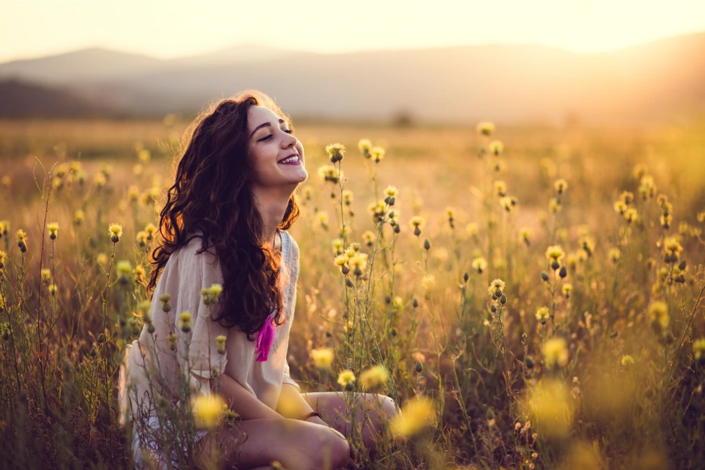 girl sitting on a blossom meadow