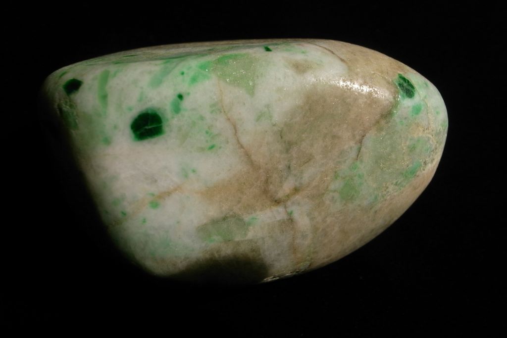 A polished Jadeite crystal on a black background