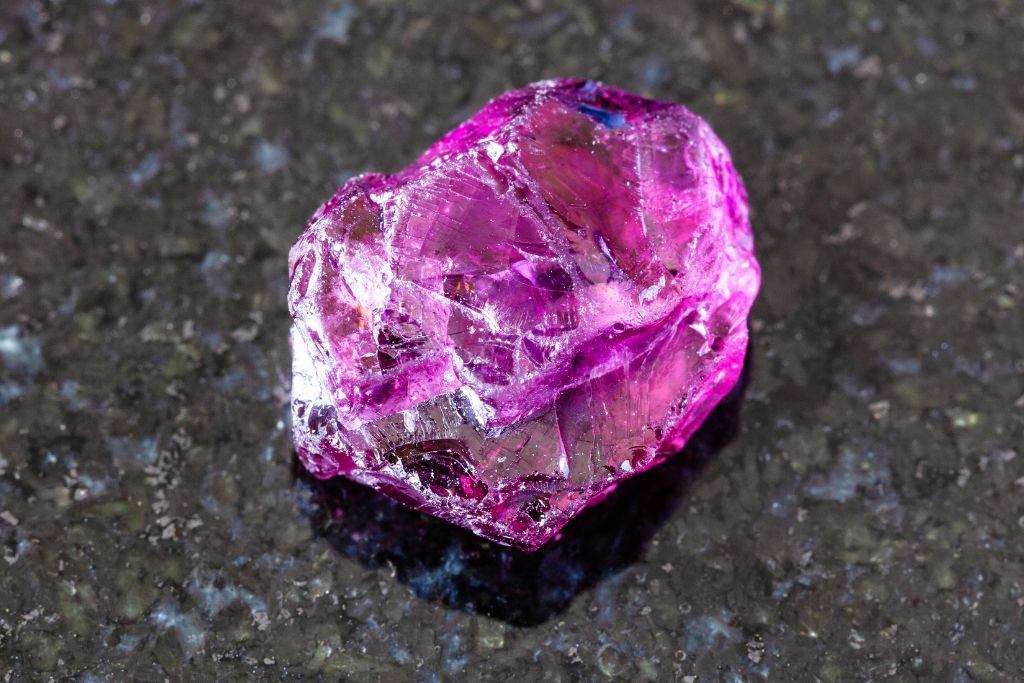 A Rhodolite crystal on a black granite