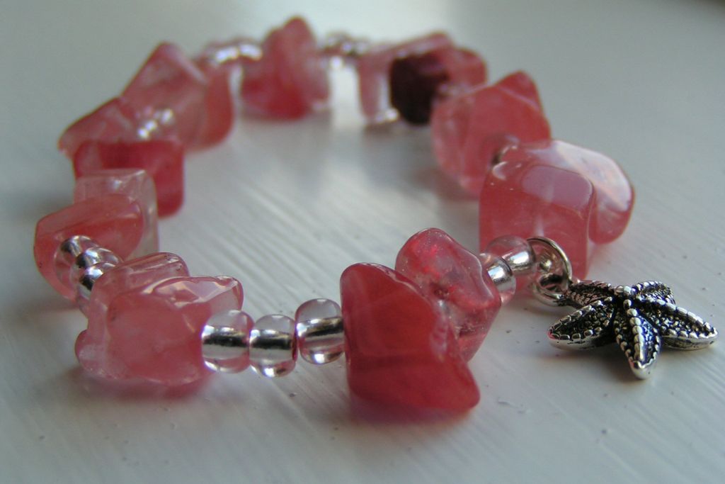 A Strawberry Quartz (Cherry Quartz) bracelet on the table. Source: Flickr | Madzik