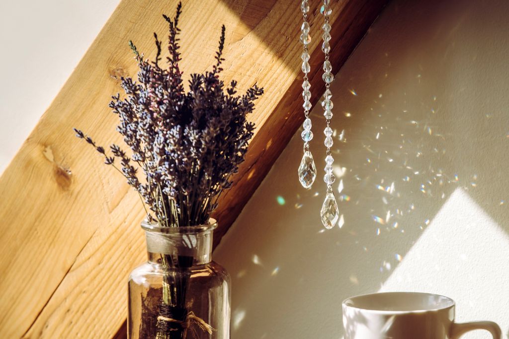 crystal suncatcher hanging on a living room beside a glass jar