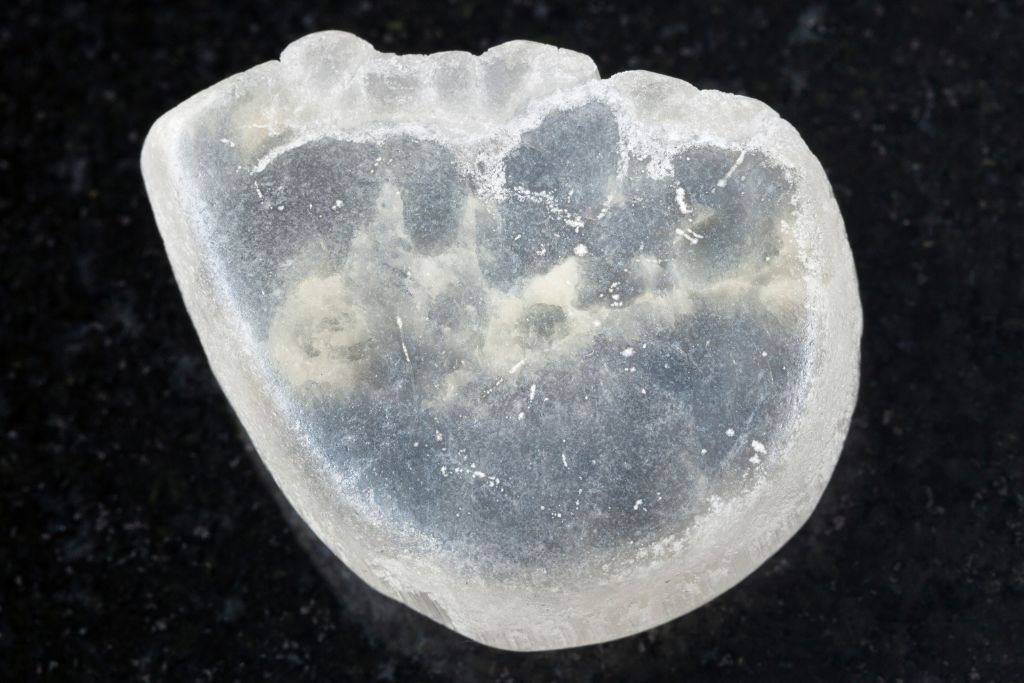 An Ulexite crystal on a black granite crystal