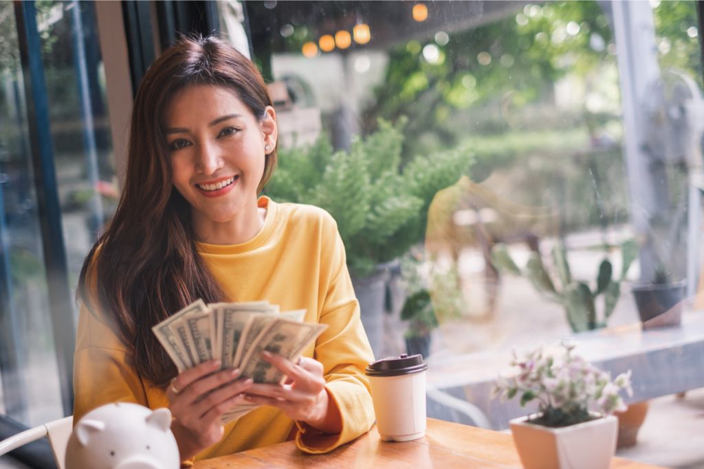 Woman holding money in a cafe
