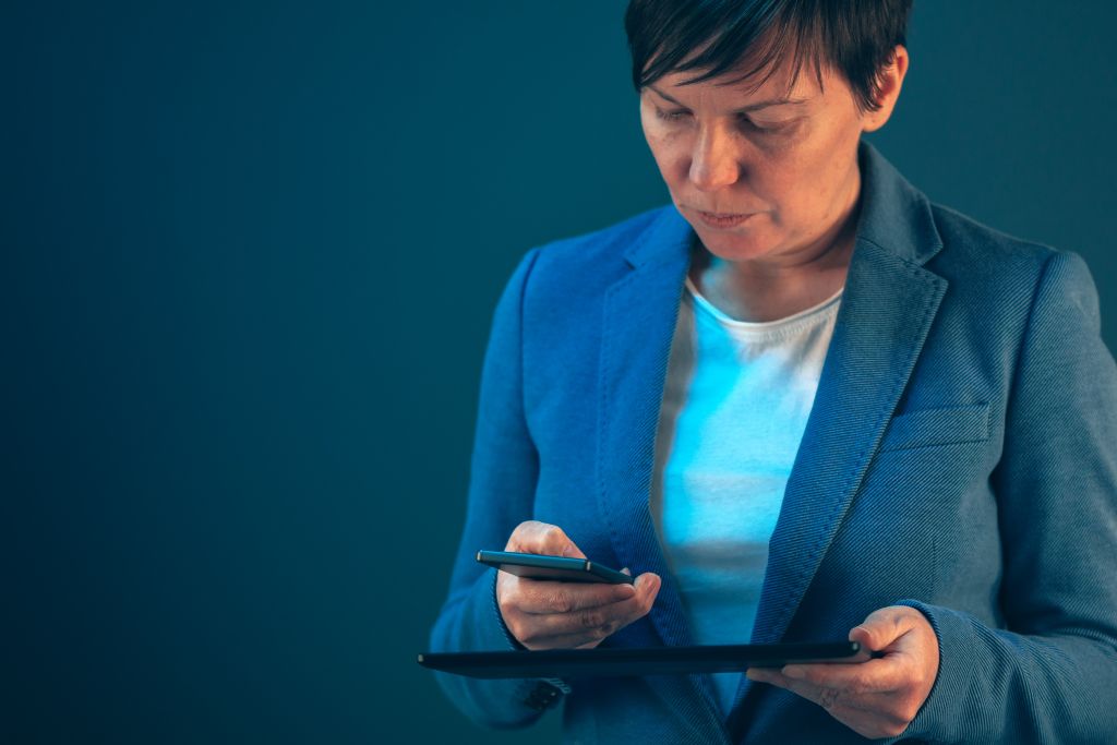 woman in business attire looking at her phone