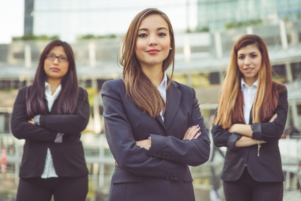 three women in business suits smiling
