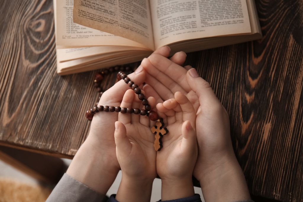 woman and a child holding a rosary 