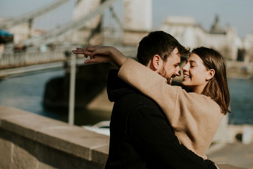 happy couple hugging each other near the london bridge