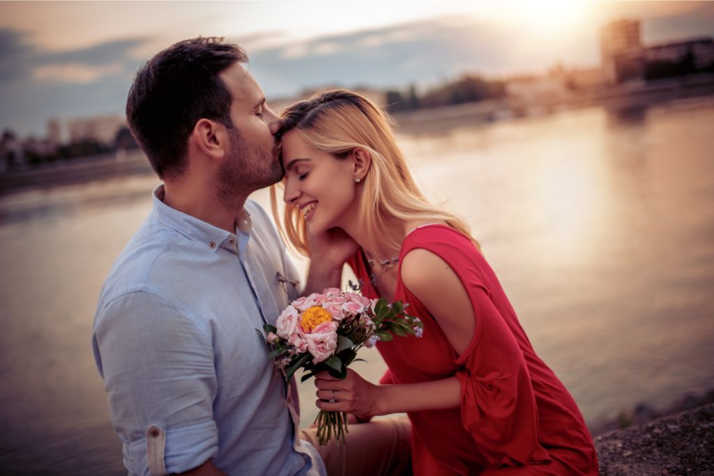 A man kissing the head of a woman