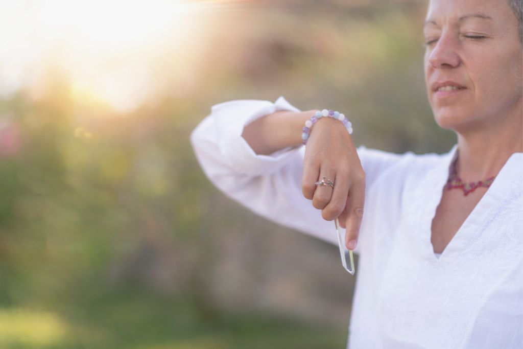 woman meditating while holding a crystal