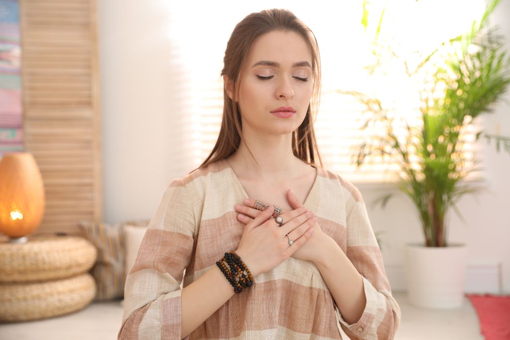 A young woman touching her chest during self healing session