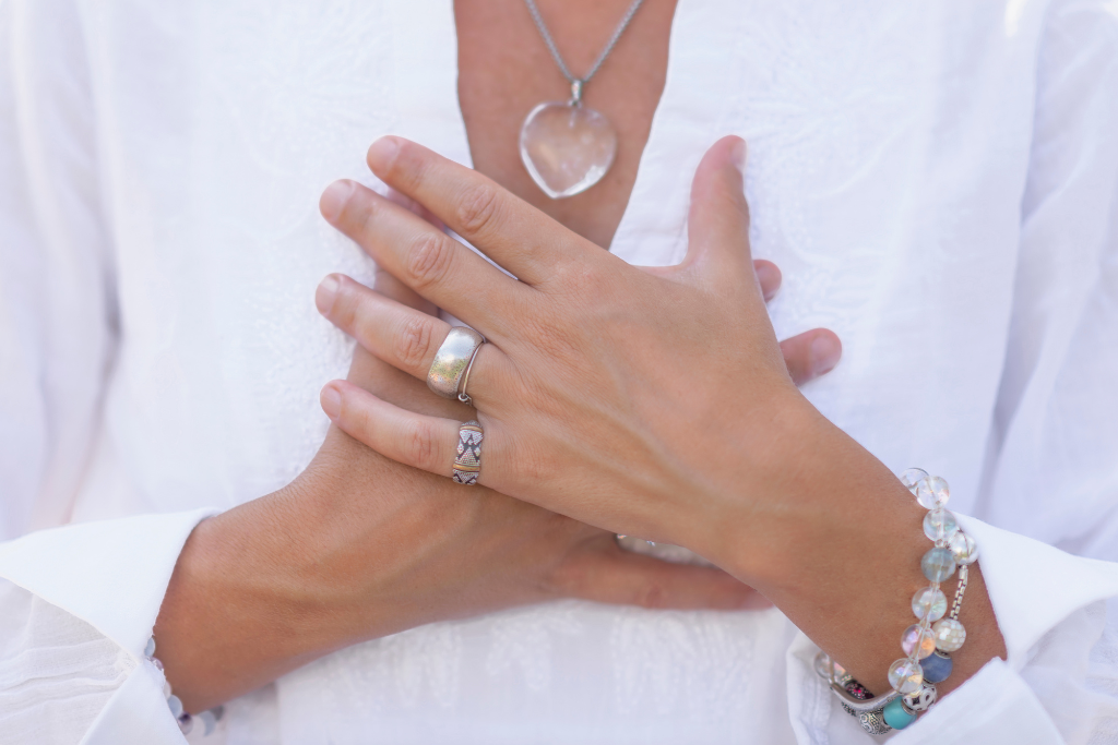 woman holding her hands to her chest in a mindful manner