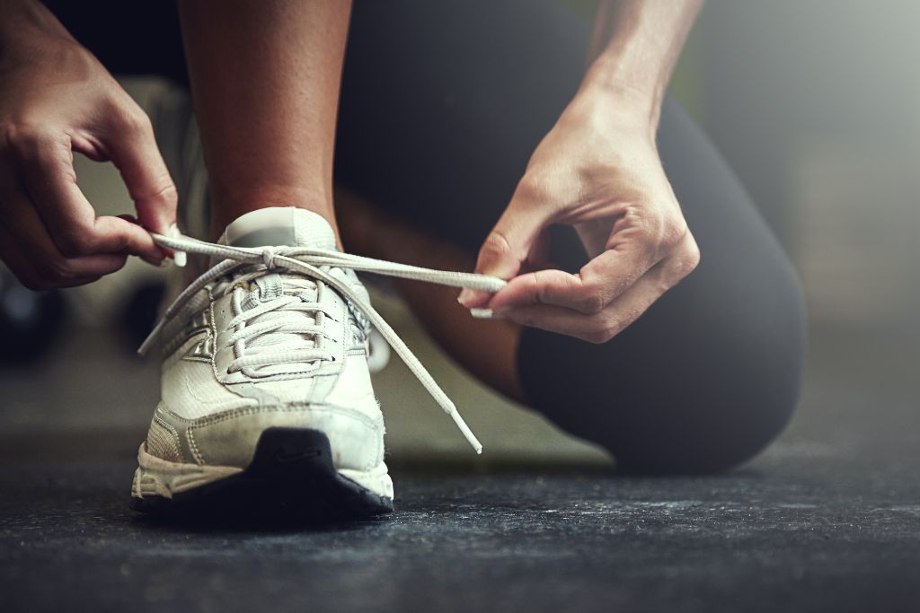 A person fixing her shoe lace