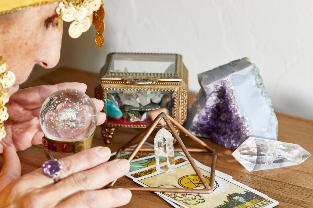 A psychic looking at a crystal ball on the table