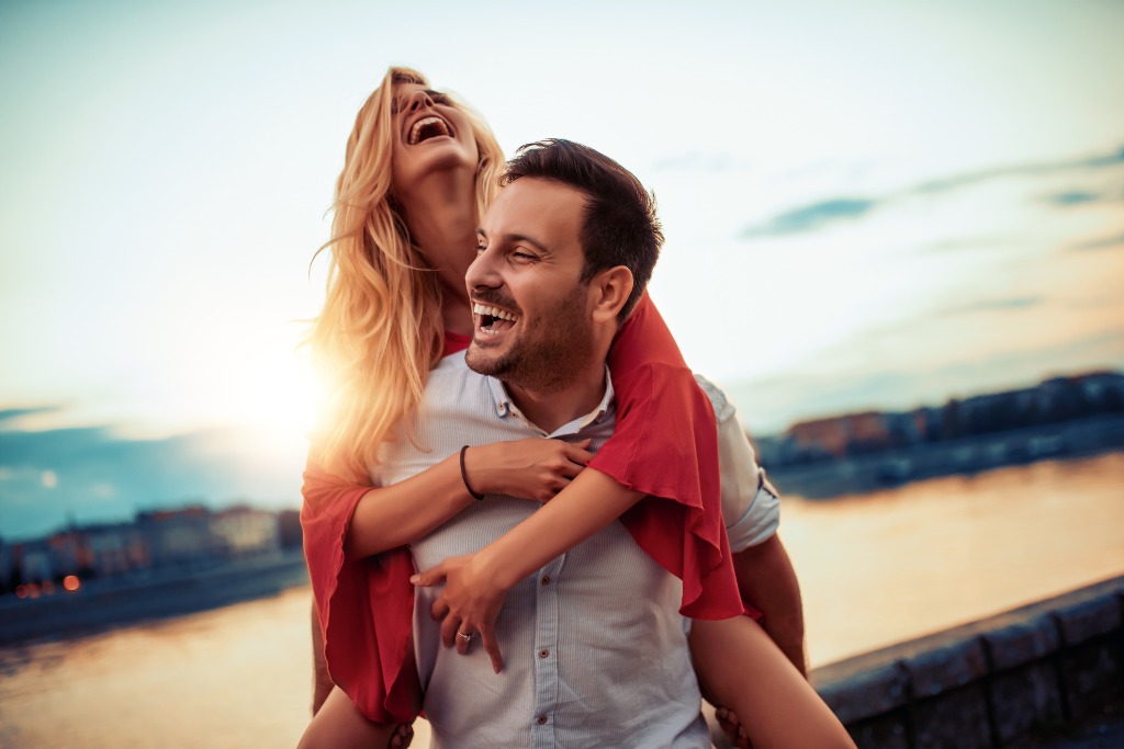 A man is giving a woman a piggy back ride