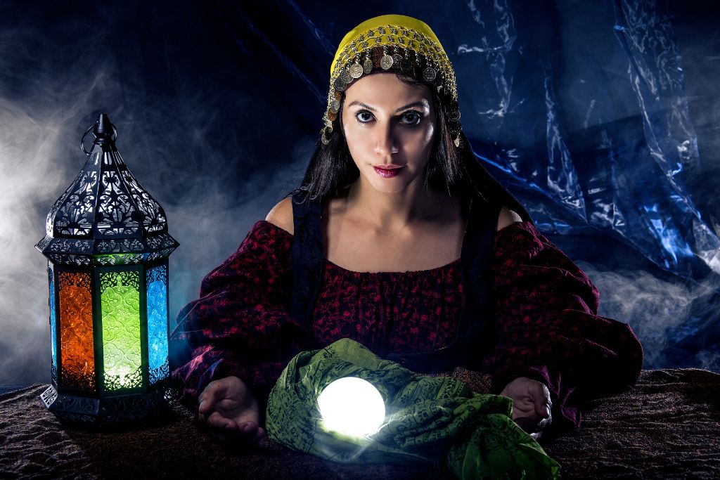 A woman is sitting at the table with a crystal ball