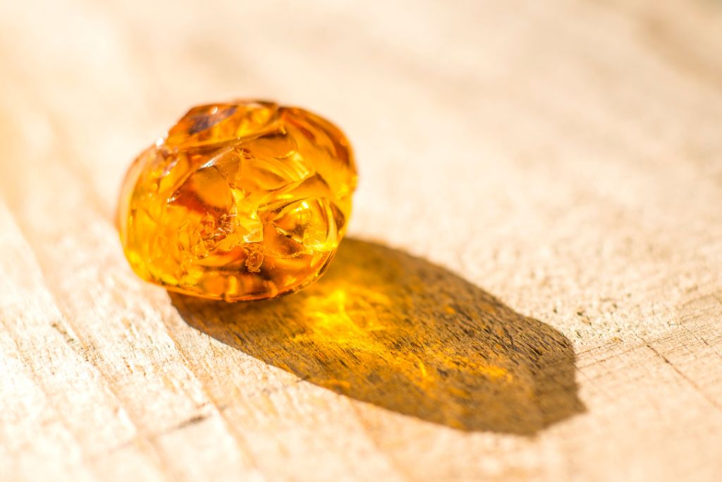 An amber crystal on a wooden table