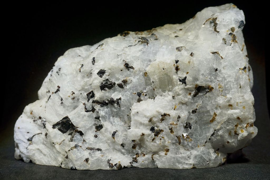 A Cryolite crystal on a dark background. Source: WikiMedia | Charlie Smith