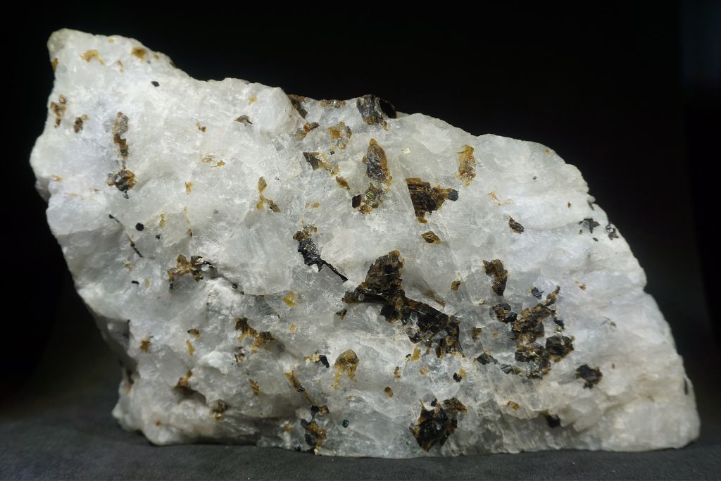 A Cryolite crystal on a dark background. Source: WikiMedia | Charlie Smith
