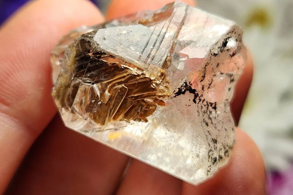 a woman holding a chunk of Elestial Quartz. Image Source: Elestial Quartz | Lauren-InfiniteSpiral