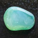 A Green Calcite crystal on a black granite