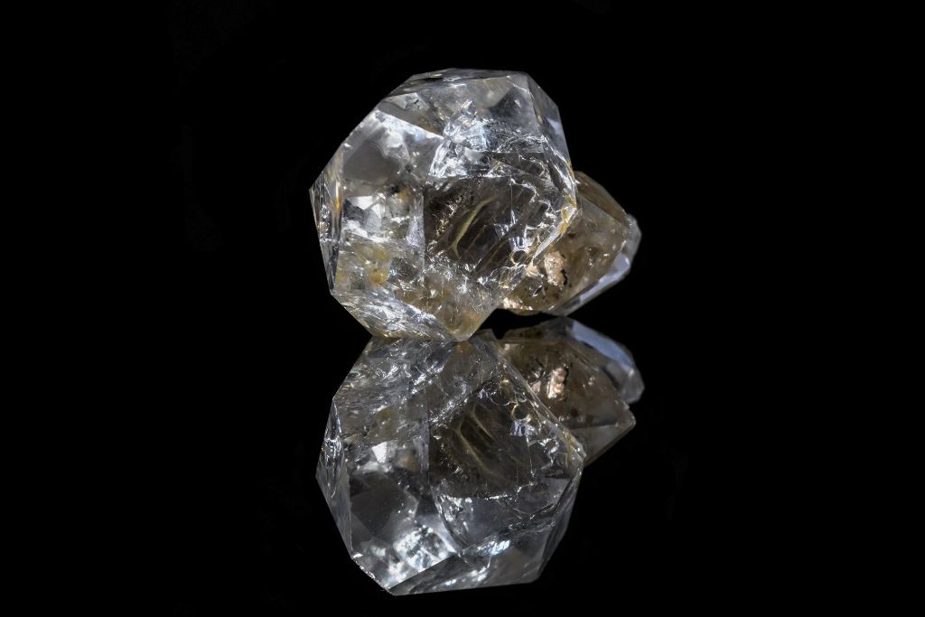 A Herkimer Diamond on a black reflective background