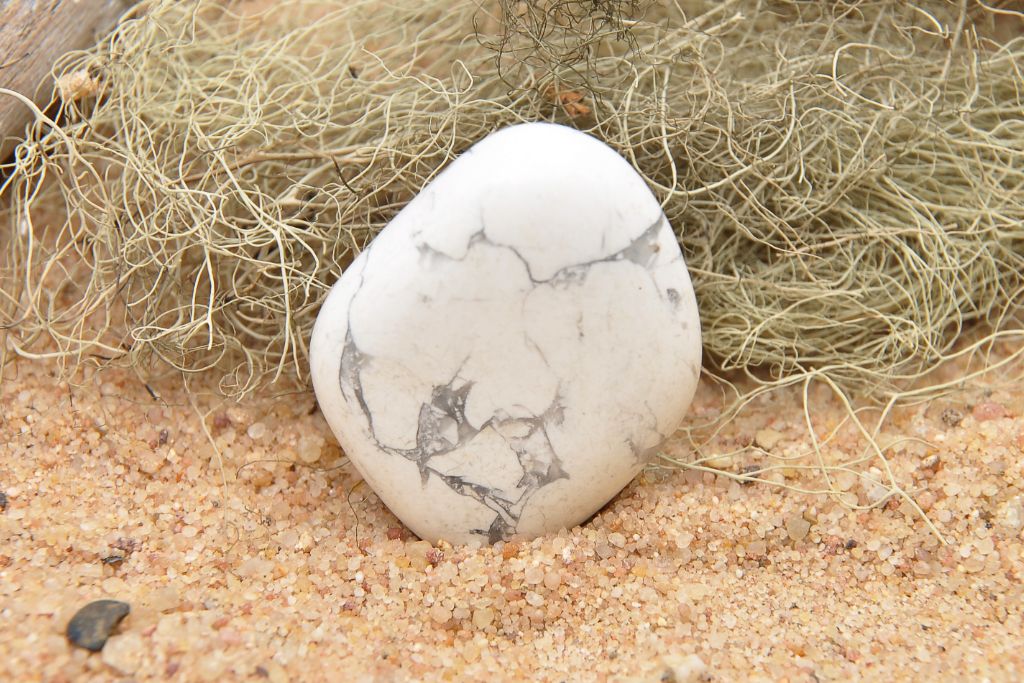 Howlite crystal placed on a beach sand