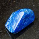 A lazurite crystal on a dark granite